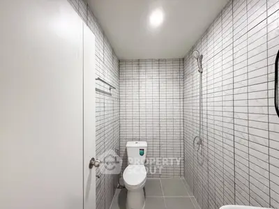 Modern minimalist bathroom with sleek tile design and contemporary fixtures.