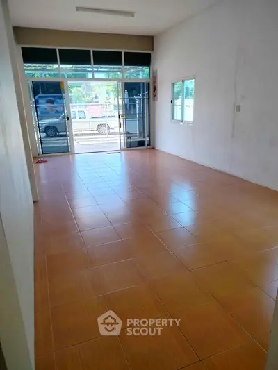 Spacious tiled room with large windows and street view, perfect for versatile use.