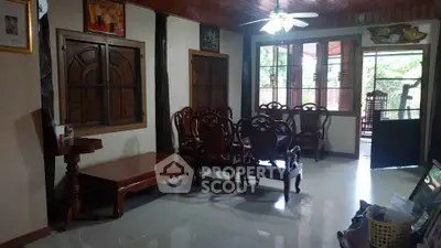 Charming living room with wooden furniture and large windows offering natural light.