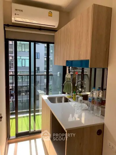 Modern compact kitchen with sleek cabinetry and large window view