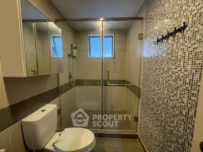 Modern bathroom with glass shower enclosure and stylish tile design.