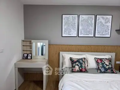 Chic bedroom with stylish decor and cozy bedding, featuring a modern vanity and city map artwork.