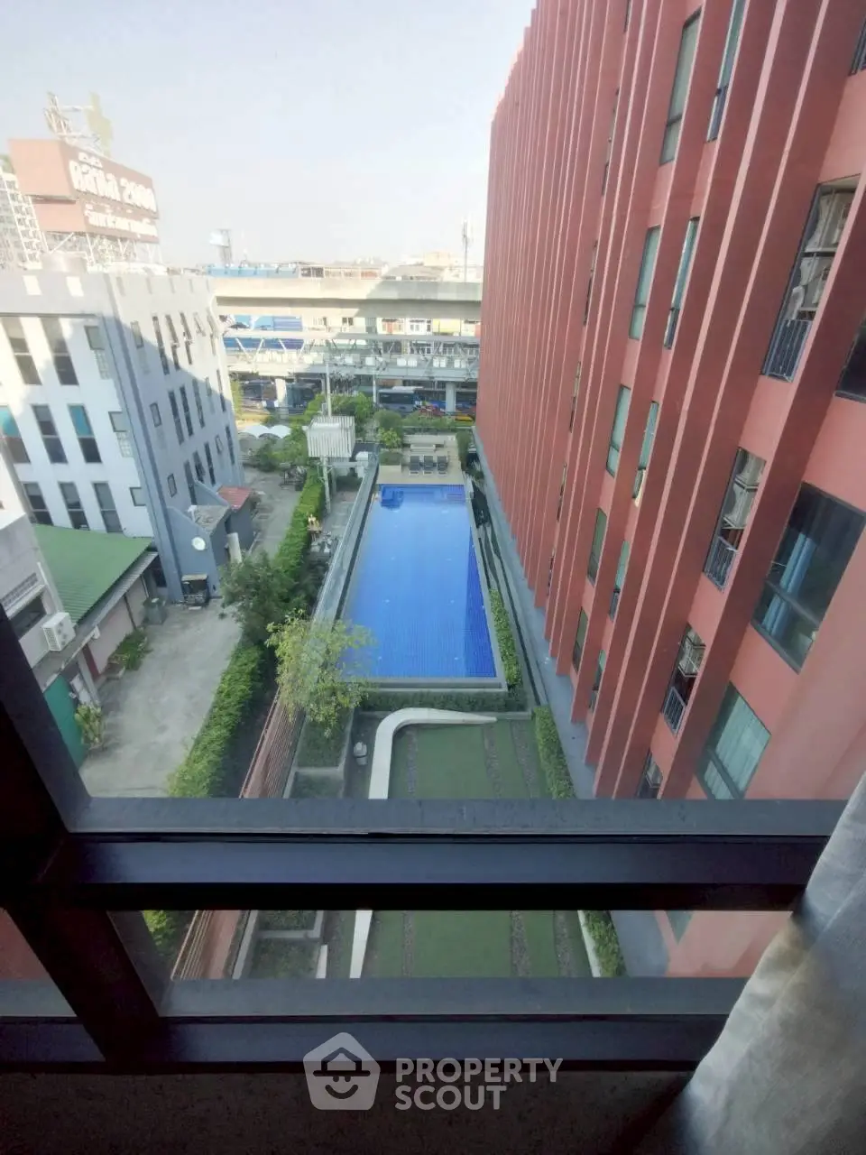 Stunning aerial view of modern apartment complex with inviting swimming pool and lush greenery.