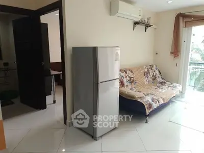 Cozy living room with fridge and sofa, bright natural light, and balcony view.