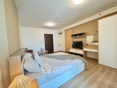 Spacious modern bedroom with stylish decor and ample natural light
