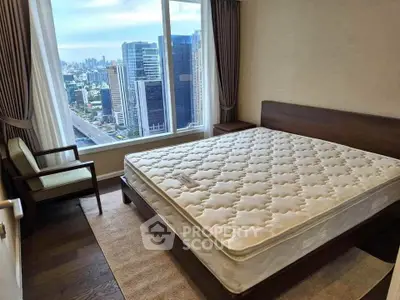 Modern bedroom with city view, featuring a large window and elegant furniture.