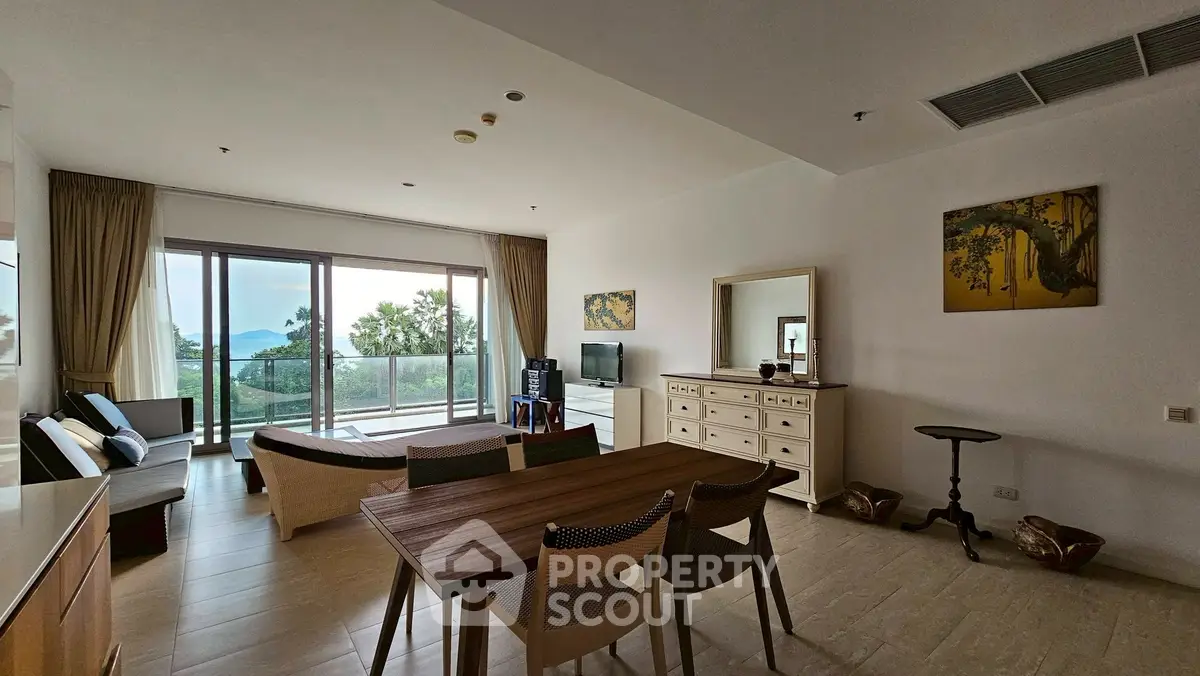 Spacious living room with modern decor and stunning sea view balcony in luxury apartment.
