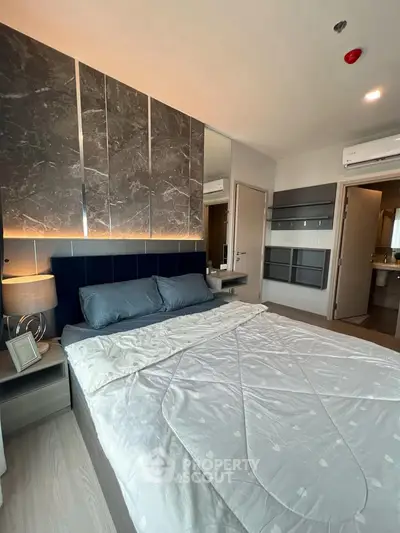 Modern bedroom with stylish decor and ambient lighting in a contemporary apartment.