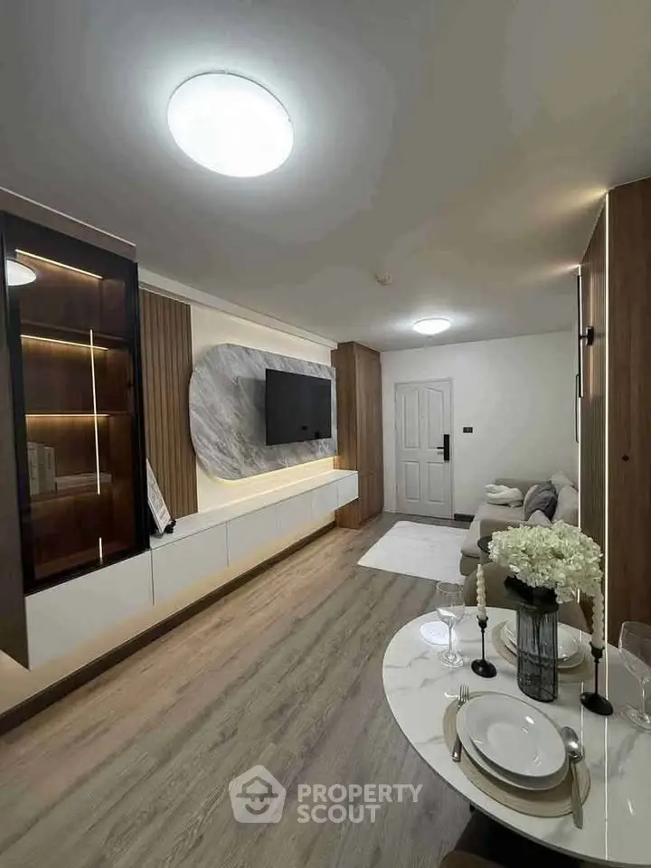 Modern living room with stylish decor and elegant dining setup, featuring a sleek TV unit and cozy seating area.