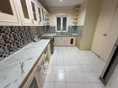 Spacious kitchen with modern cabinetry and stylish tile backsplash, perfect for culinary enthusiasts.