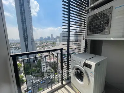 High-rise balcony with city view, featuring washing machine and air conditioning unit.