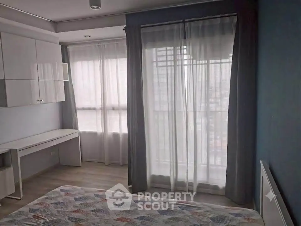 Modern bedroom with large windows and stylish decor in a high-rise apartment.