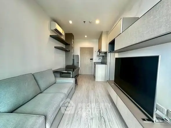 Modern living room with sleek furniture and large TV in a stylish apartment.