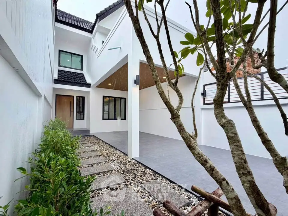 Modern minimalist house exterior with sleek design and lush greenery
