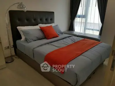Modern bedroom with stylish decor and large window for natural light.