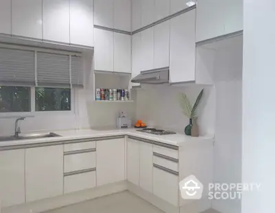 Modern white kitchen with sleek cabinets and minimalist design