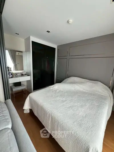 Cozy modern bedroom with stylish decor and ample natural light