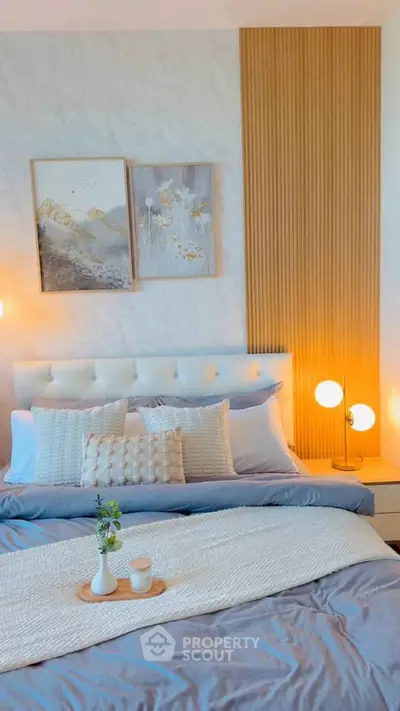 Elegant bedroom with stylish decor and cozy lighting, featuring a plush bed and modern artwork.