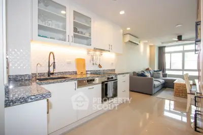 Modern open-layout kitchen and living room with sleek design and ample natural light.