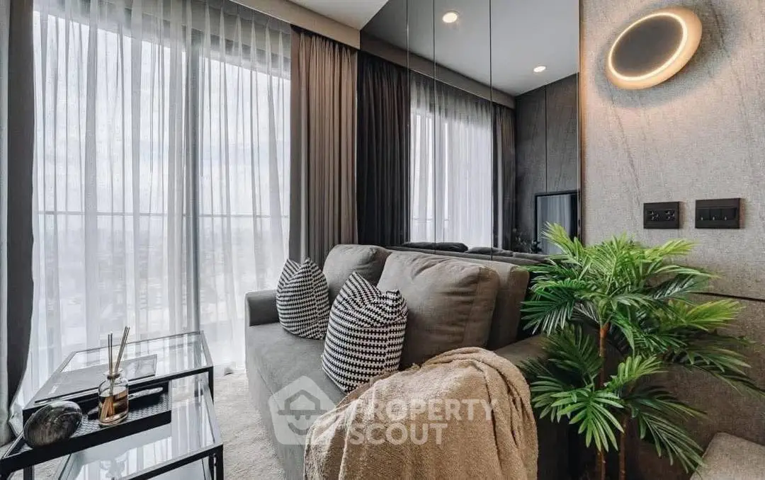 Modern living room with stylish decor, large windows, and cozy seating area.