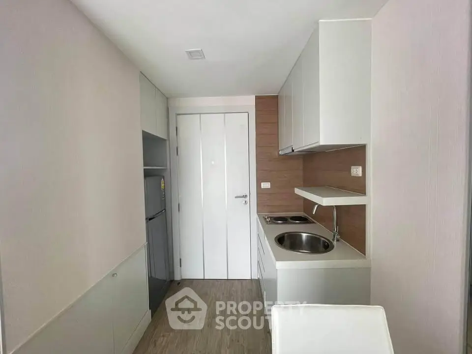 Modern compact kitchen with sleek cabinetry and integrated appliances