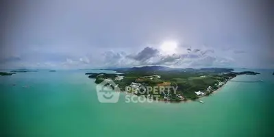 Stunning aerial view of a serene island with lush greenery and turquoise waters, perfect for luxury real estate.