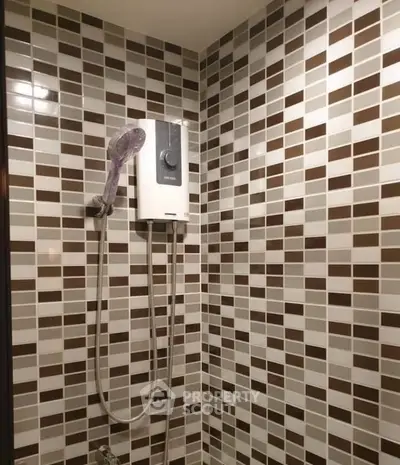 Modern bathroom with stylish tiled walls and electric shower unit.