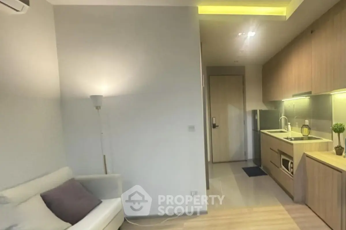 Modern apartment interior with cozy living area and sleek kitchen design.