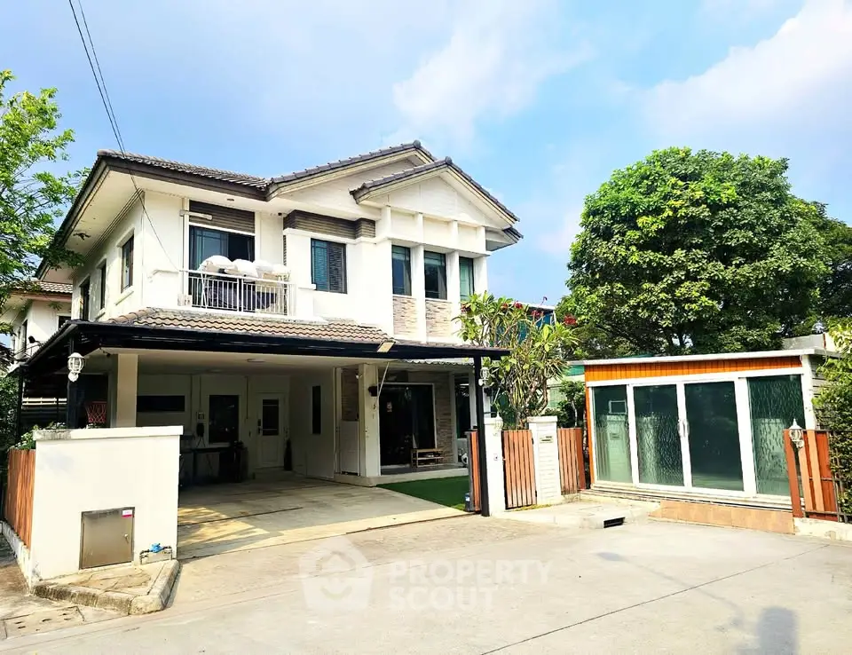 Charming two-story house with spacious driveway and lush greenery, perfect for family living.