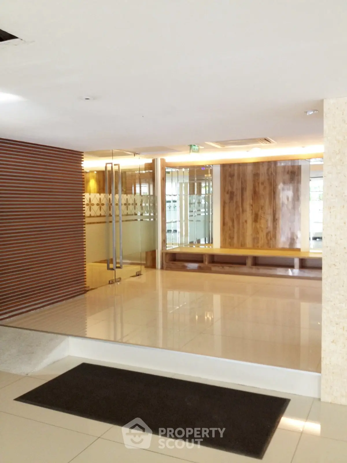 Modern building entrance with sleek glass doors and elegant wood paneling