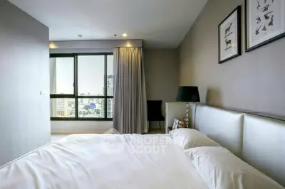 Modern bedroom with city view and elegant decor in a high-rise apartment.