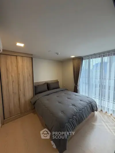 Modern bedroom with wooden wardrobe and large window for natural light
