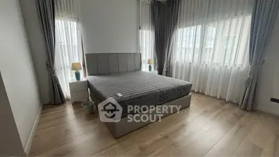 Spacious bedroom with elegant decor and large windows for natural light