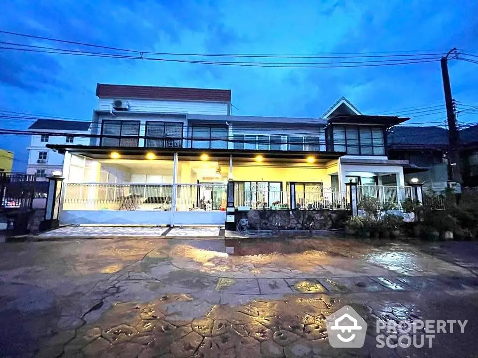 Stunning two-story house with modern design and spacious outdoor area at dusk