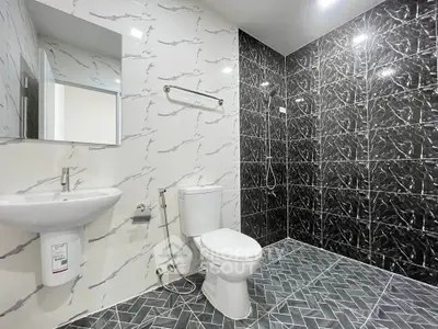 Modern bathroom with stylish black and white marble tiles and sleek fixtures.