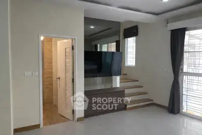 Modern living room with sleek TV unit and staircase