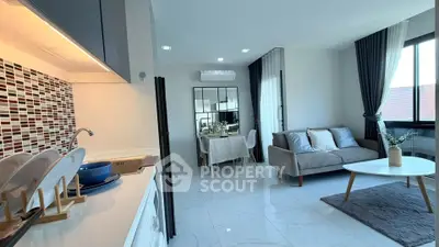 Modern open-plan living room and kitchen with stylish decor and natural light.