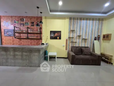 Stylish living room with modern bar counter and cozy sofa, perfect for entertaining guests.