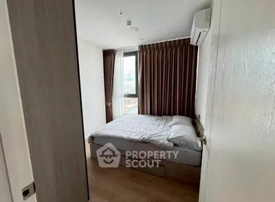 Modern bedroom with large window and air conditioning in a high-rise apartment.