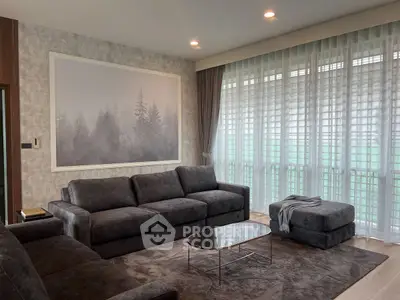 Elegant living room with modern gray sofas and large window, perfect for relaxation.