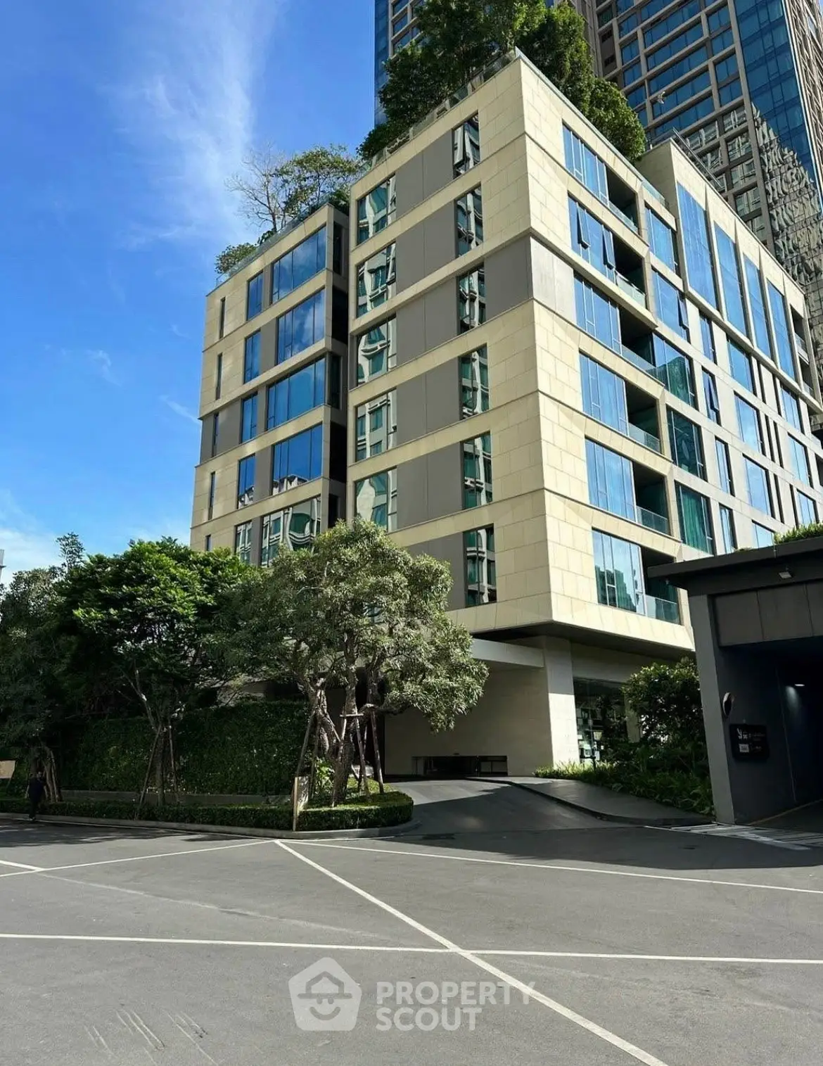 Modern apartment building with lush greenery and sleek design in urban setting.