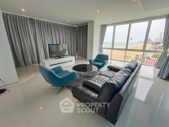 Spacious beachfront living room with modern furniture and stunning ocean view.