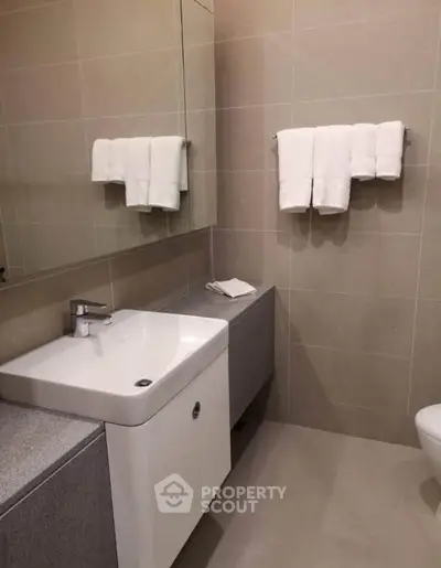 Modern bathroom with sleek sink and towel setup, ideal for contemporary living.