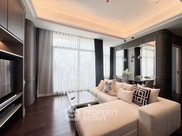 Luxurious modern living room with elegant decor and large windows offering natural light.