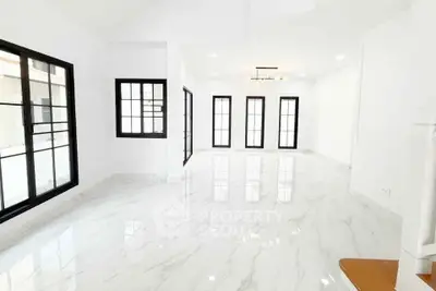 Spacious modern living room with marble flooring and large windows for natural light.