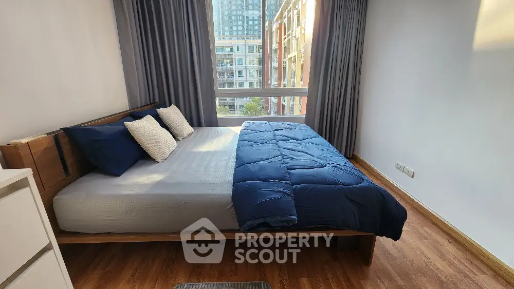 Modern bedroom with large window and stylish decor in urban apartment