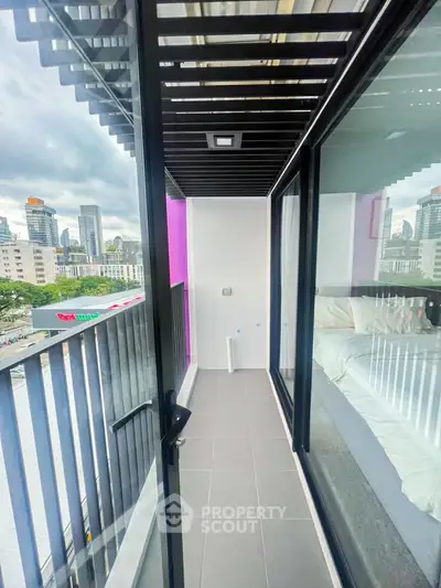 Modern apartment balcony with city view and sleek glass doors