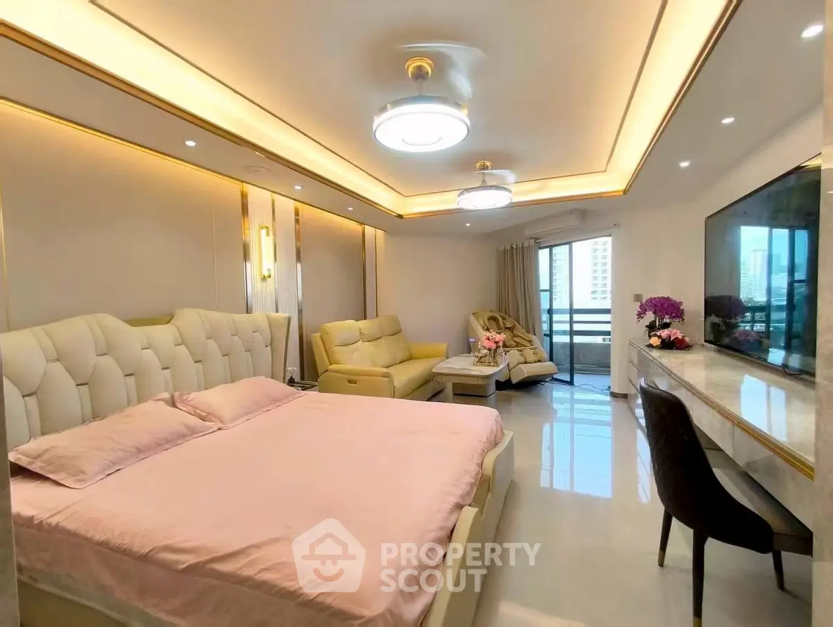 Luxurious bedroom with elegant decor and spacious layout, featuring a cozy seating area and large windows.