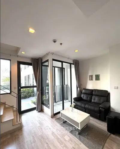 Modern living room with sleek design, large windows, and cozy seating area in a stylish apartment.
