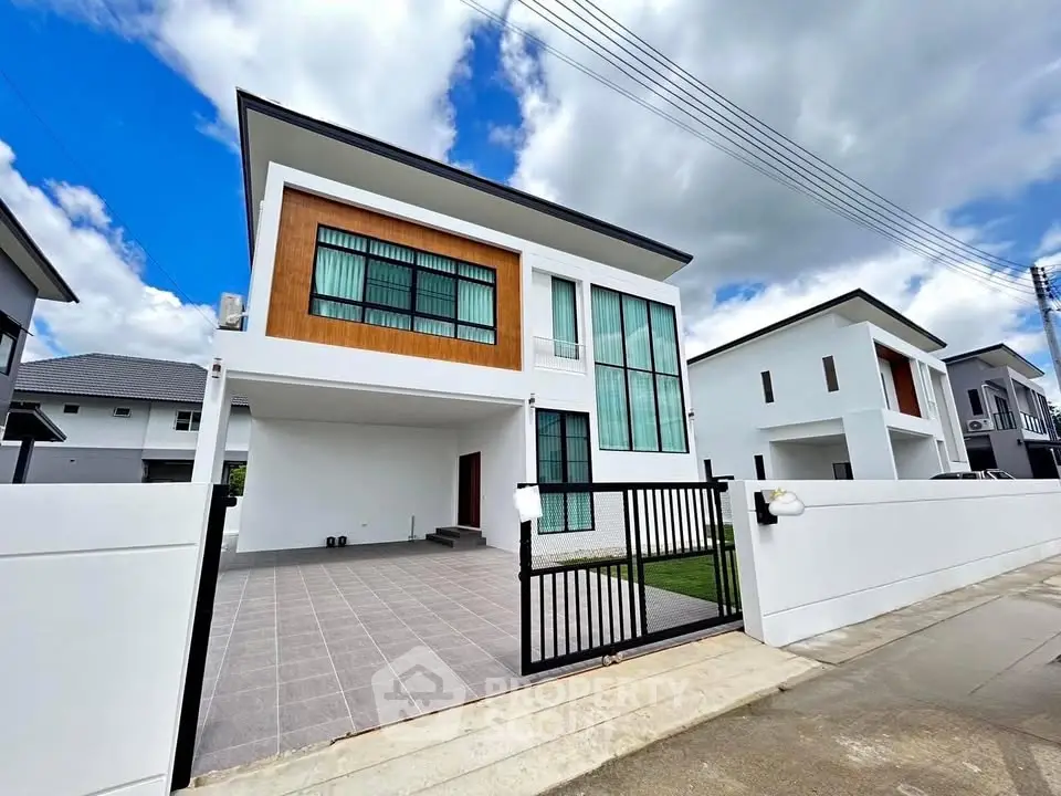 Modern two-story house with sleek design and spacious driveway in suburban neighborhood.